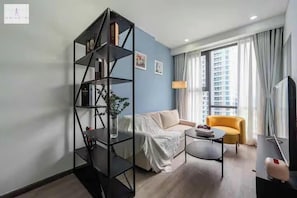 Appartement Prestige, 1 chambre, vue sur la ville | Aire de séjour | Téléviseur à écran plat de 24 po avec télévision par câble, livres