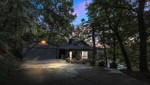 A house with a garage, surrounded by trees and a driveway. - *NEW* Waterfront Treehouse - Sweeping Views on 2.5 Acres (Knoxville)
