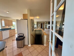 A modern kitchen with a dishwasher, a trash can, and a countertop. - Luxurious Hilltop Home w/ Private Hot Tub and Direct Dune Access (Winchester Bay)