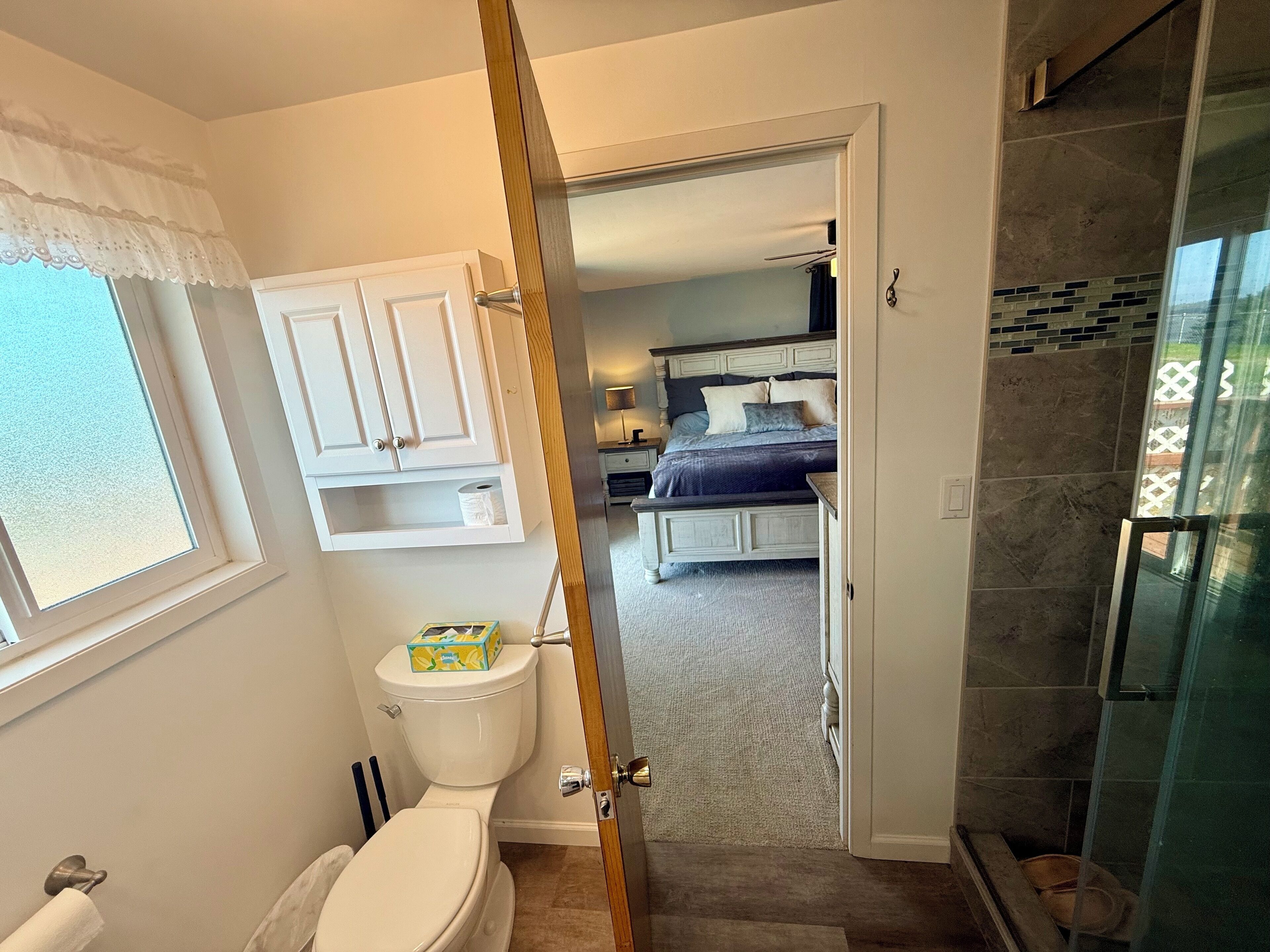 Une salle de bain comprenant des toilettes, un meuble et un espace douche.
