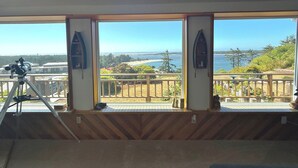 A room with large windows offering a view of a beach and ocean.