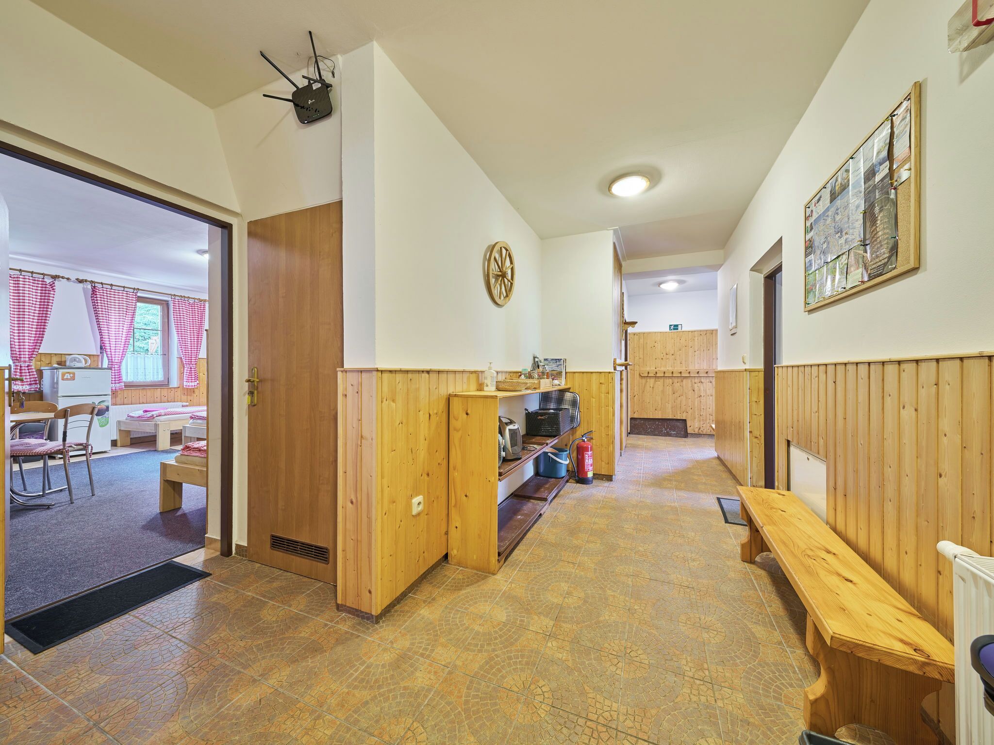 Una habitación acogedora con un banco de madera, una mesita y una pequeña cocina.