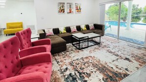 A modern living room with a sectional sofa, a coffee table, and a vibrant rug. - Charming Villa with Pool and Lake View (Miramar)
