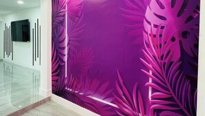A modern interior with a reflective floor, a wall with a vibrant abstract design, and a geometric light fixture. - Charming Villa with Pool and Lake View (Miramar)
