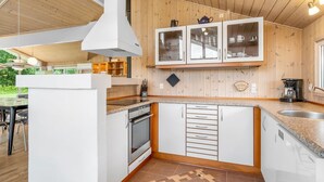 Une cuisine moderne avec des meubles blancs, un four encastré et un plan de travail en granit.