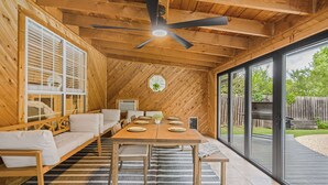 A wooden interior with a dining table set for six, a sofa, and a ceiling fan. - Austin Escape w/ Pool, Hot Tub & Game Room – DT ,Bars, South Congress, Airport ! (Austin)
