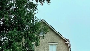 Et toetagers hus med en veranda, en altan og en murstensfacade.