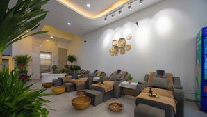 A modern spa area with multiple massage chairs, a reception desk, and decorative wall art.