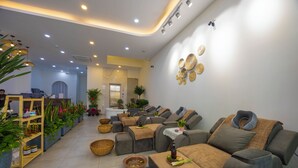 A modern spa with multiple massage chairs, a reception area, and various plants and baskets.