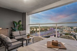 Un balcone con vista sulla città, un divano, un tavolo e una sedia.