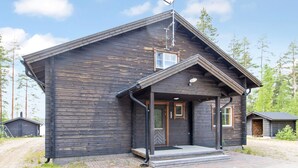 Une cabane en bois avec une antenne parabolique, une véranda et une petite fenêtre.