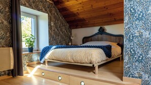 Une chambre à coucher avec un lit, un plancher en bois et une fenêtre.