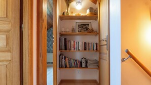Un couloir étroit doté d’étagères en bois où sont rangés des livres, ainsi qu’une bouilloire.