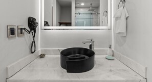 A bathroom with a large mirror, a hairdryer, a sink, and a towel rack. - Quadrant 206: Pool, Gym & Padel – Walk to Beach! (Bucerías)