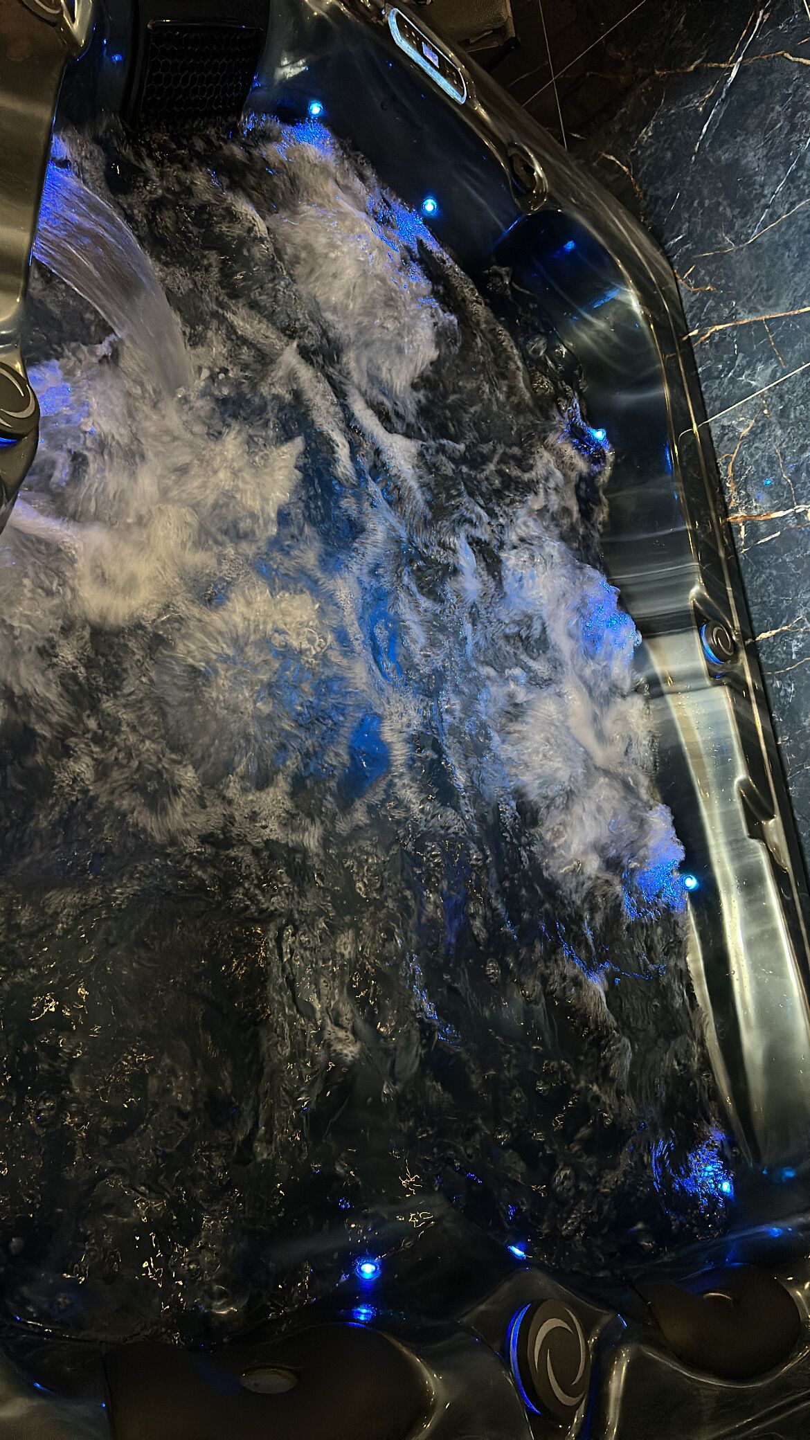 Un jacuzzi con chorros de agua y luces LED azules.