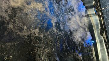 Un jacuzzi con chorros de agua y luces LED azules.