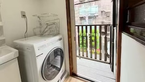 A laundry area with a washing machine and a drying rack. - Akabanenishi Kodate (Tokyo)