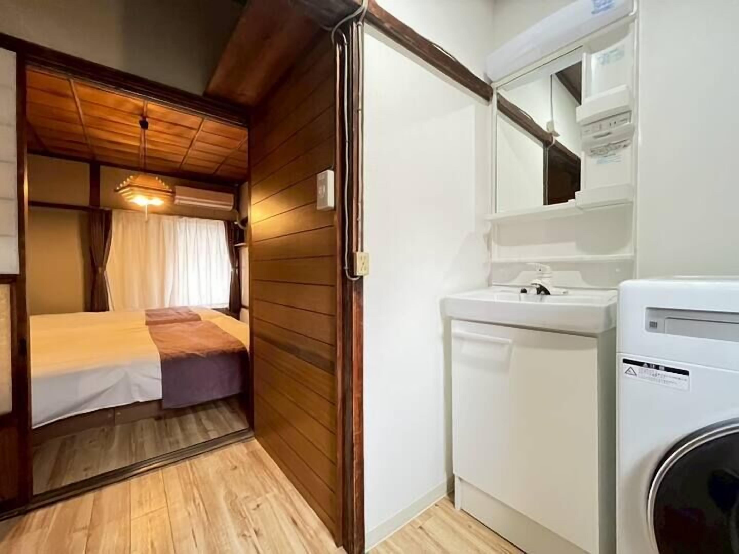A compact RV interior with a bed, a small sink, and a compact kitchen area.