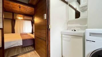 A compact RV interior with a bed, a small sink, and a compact kitchen area.