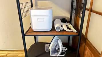A bunk bed with a white appliance on the top shelf, a hairdryer and other items on the middle shelf, and an iron on the bottom shelf.