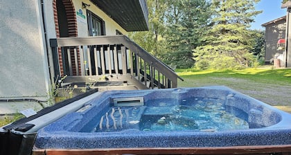 Spacious 6-bedroom Swiss style chalet in with Hot-tub for 14 people .