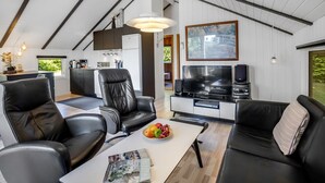 A modern living space with a kitchen, dining area, and entertainment setup.