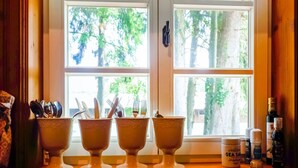 Ein Fenster mit drei weißen Schüsseln auf einer Holzablage, einer Flasche Sea Salt und einem Butterglas.