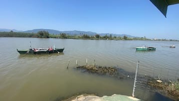 A calm lake with boats and a distant mountain range.