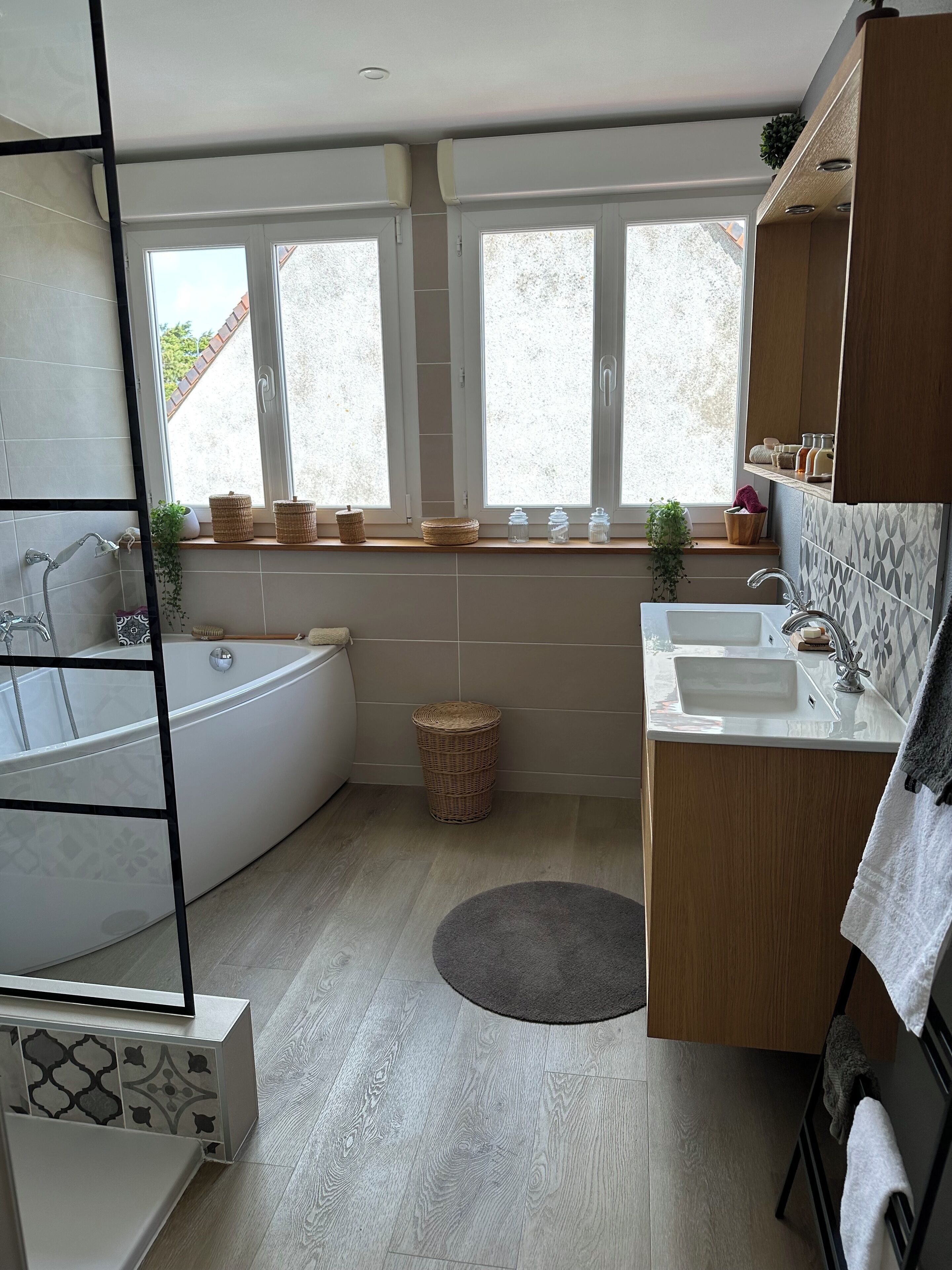 Une salle de bain moderne avec une baignoire sur pieds, un meuble-lavabo et une fenêtre donnant sur l’extérieur.