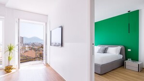 A modern bedroom with a bed, bedside table, and a green accent wall.