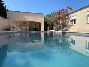 A swimming pool with lounge chairs and a patio area. - Villa l'Escapade (Canet)