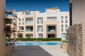 Un hôtel moderne doté d’une piscine, de balcons et de panneaux décoratifs.