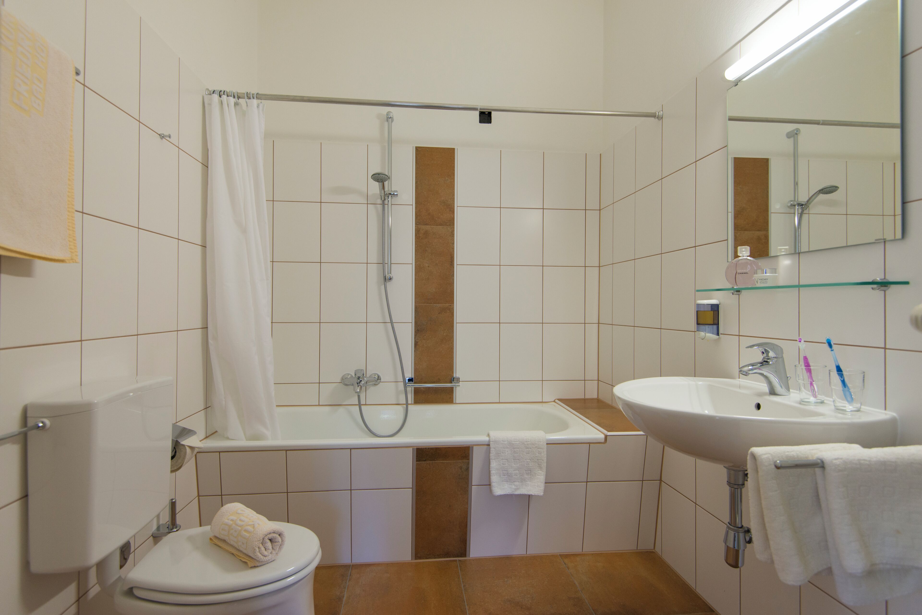 Ein Badezimmer mit Toilette, Dusche, Waschbecken und Spiegel.