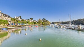 Un port de plaisance avec des bateaux amarrés, une eau calme et des bâtiments le long de la rive.