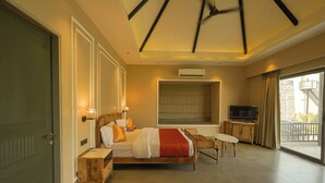 Une chambre d’hôtel avec un lit, une table de chevet, une télévision et un balcon avec vue.