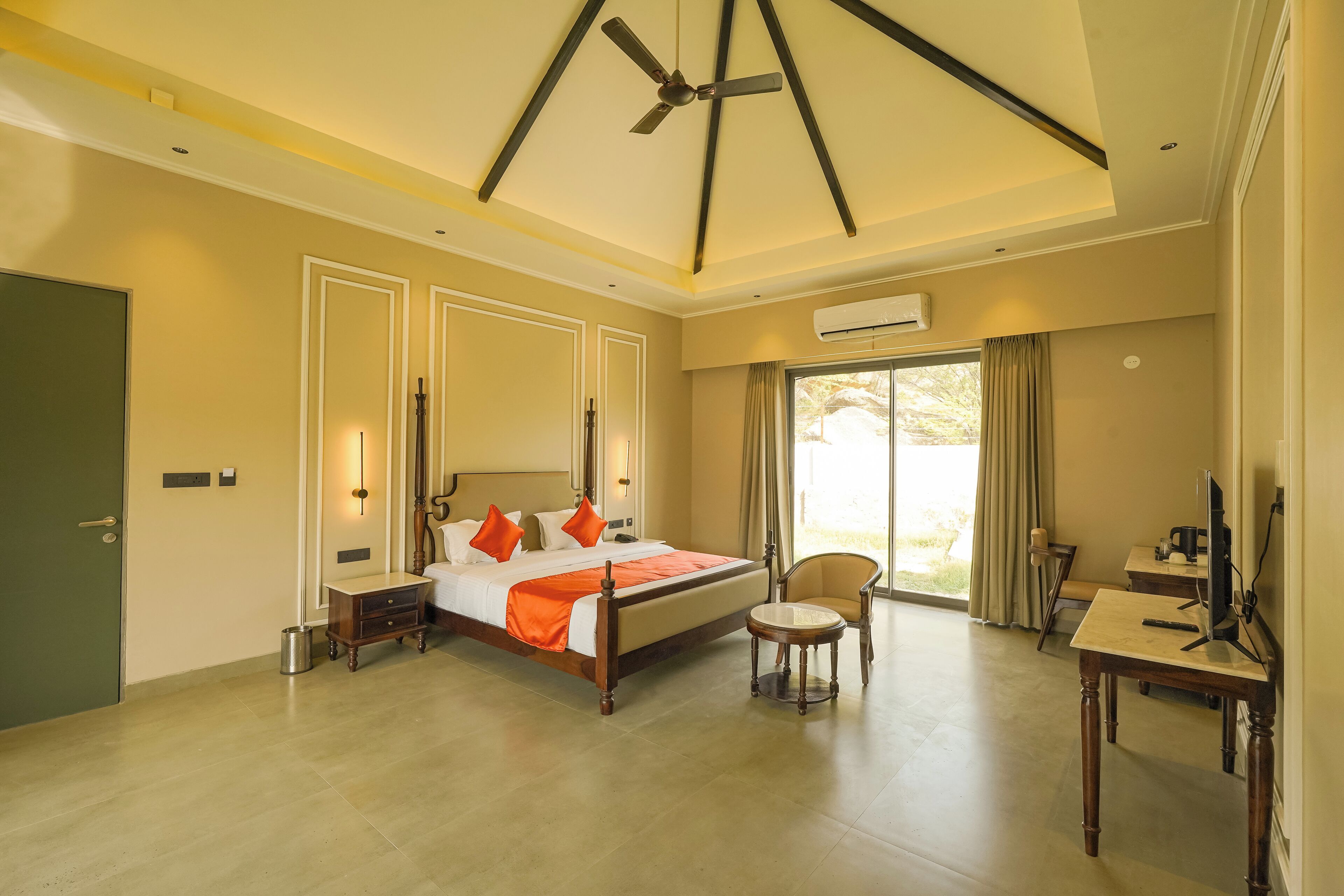 A spacious bedroom with a large bed, a desk, and a chair.