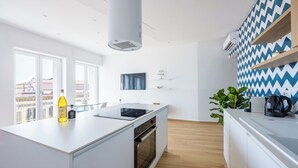 A modern kitchen with a central island, built-in oven, and a large window providing a view of the city. - At Twenty-One: new apartment with exclusive panoramic views! (Napoli)