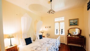 Un dormitorio con dos camas, un aparador de madera, un espejo y un ventilador de techo.