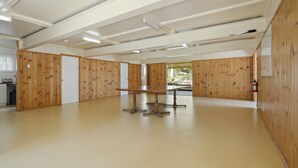 Una habitación amplia con paneles de madera, una mesa grande y vistas a un jardín.