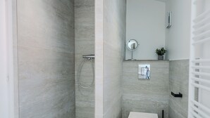 Une salle de bain moderne équipée d’une douche, de toilettes et d’un lavabo.