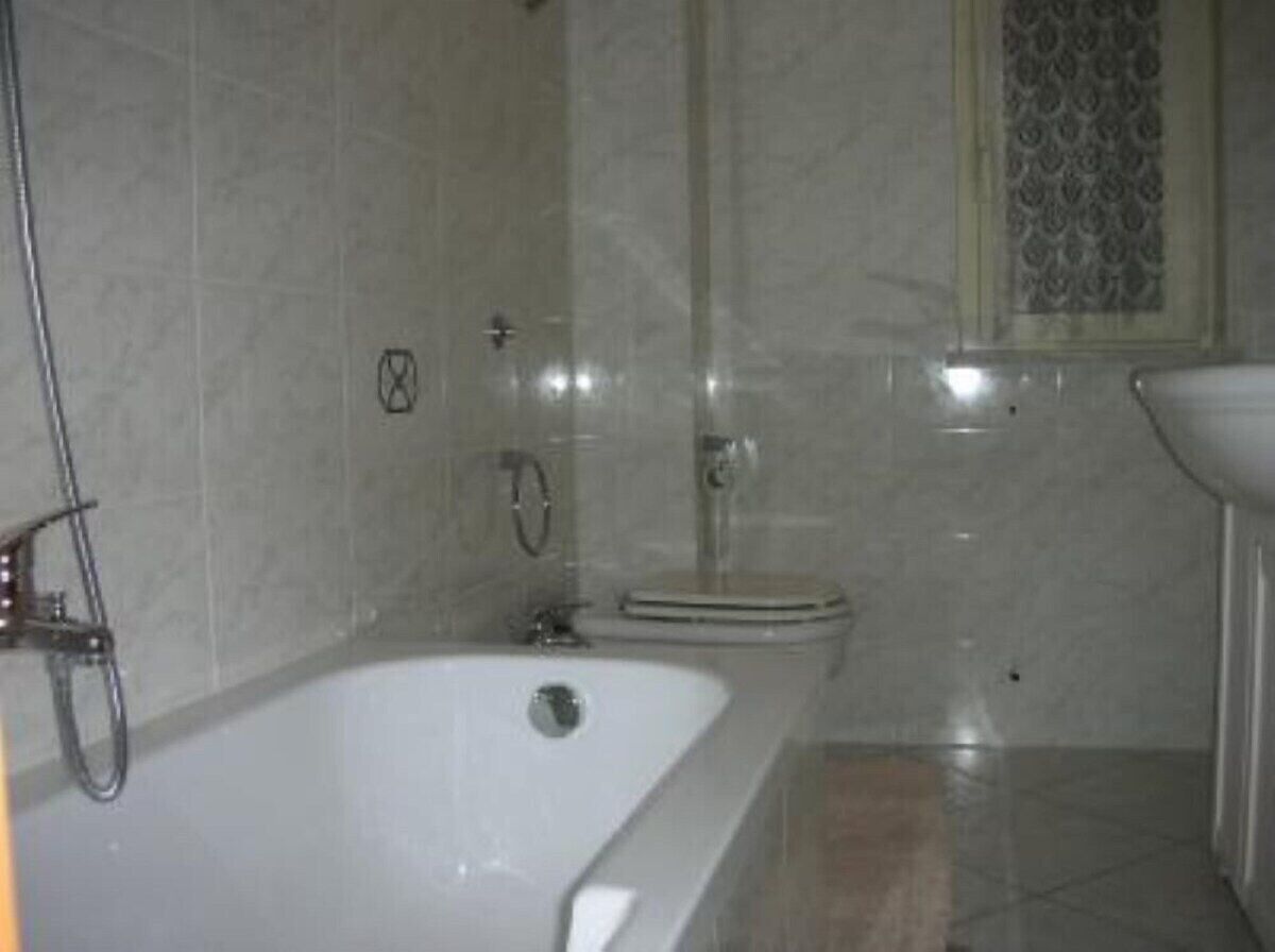 A bathroom with a bathtub, shower, and toilet.