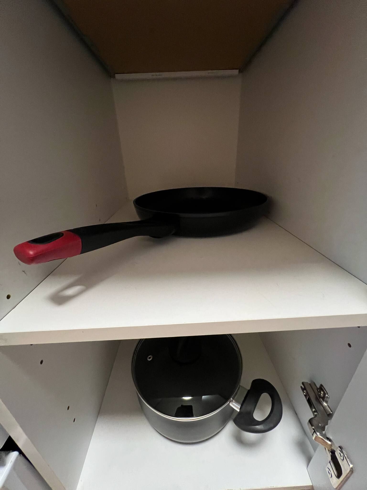 Un estante de cocina con una sartén y una olla.