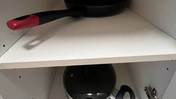 Un estante de cocina con una sartén y una olla.