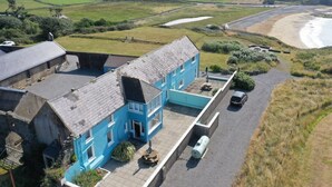 A two-story building with a flat roof, a driveway, and a parking area. - The Granary Loft at Annestown House (Annestown)
