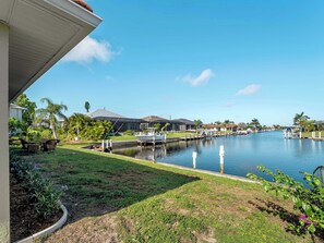 A residential area with a canal, houses, and a dock with a boat. - Punta Gorda Isles Villa On The Waterfront (Punta Gorda)