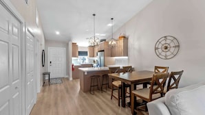 A modern kitchen with wooden cabinets, a central island, and pendant lighting. - Punta Gorda Isles Villa On The Waterfront (Punta Gorda)