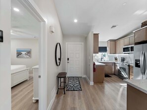 A modern kitchen with stainless steel appliances, a white door, and a hallway leading to a bedroom. - Punta Gorda Isles Villa On The Waterfront (Punta Gorda)