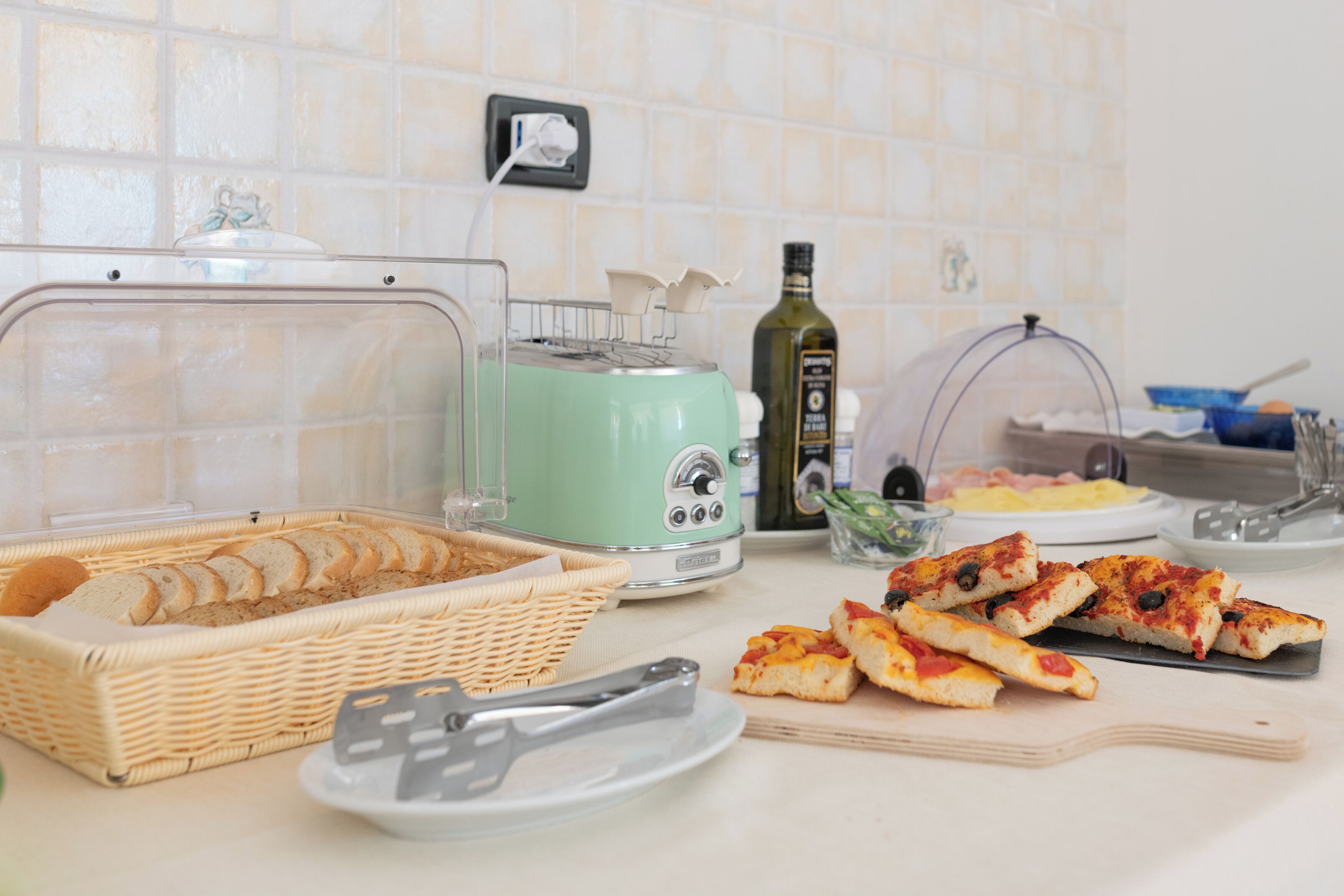 Un buffet de petit-déjeuner avec du pain, des toasts et des parts de pizza.