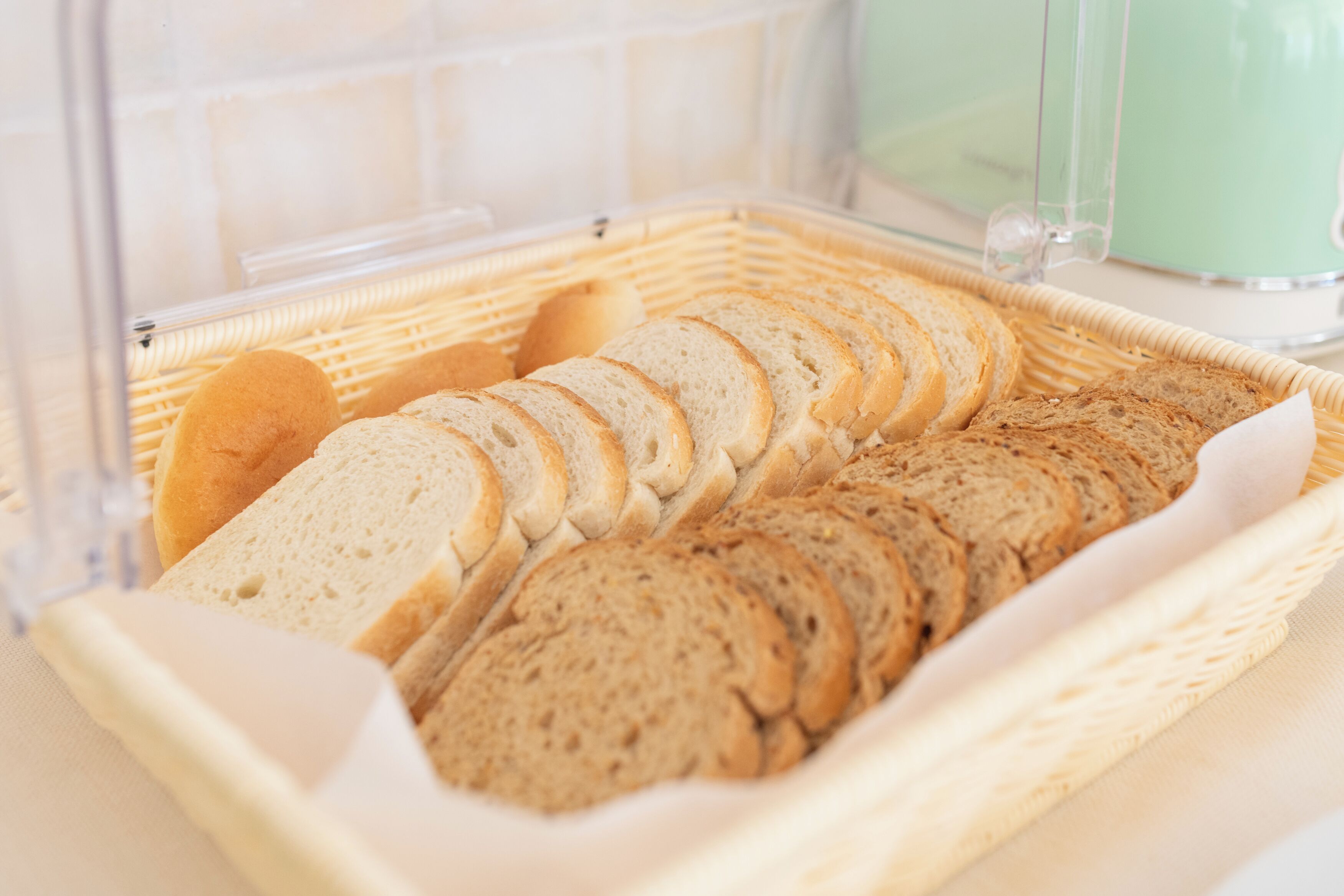 A basket of sliced bread in a clear plastic container.