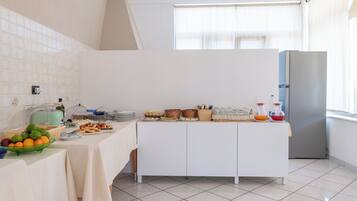 Una cocina moderna con barra de desayuno, que incluye frutas, pan y bebidas.